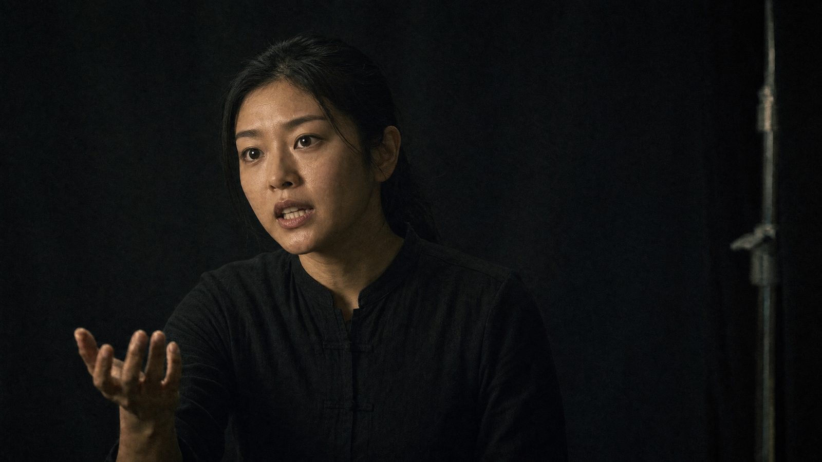 The same performance recast onto a generated East Asian character. Pose, eyeline and framing unchanged.
